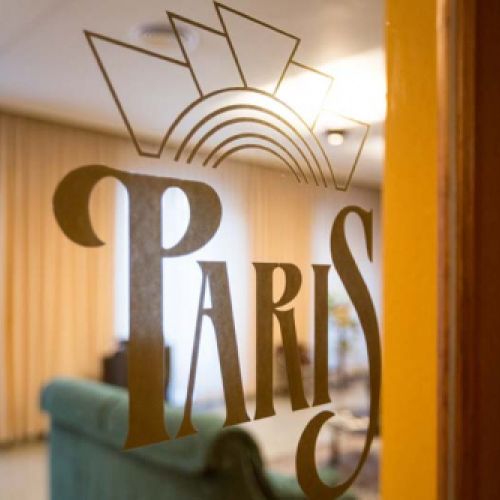 Detalle del logo del hostal junto al acceso al salón