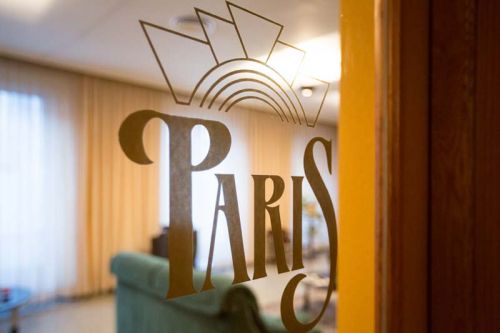 Detalle del logo del hostal junto al acceso al salón